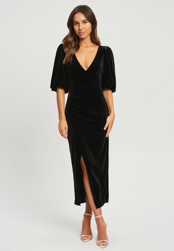 Sametové šaty s hlubším výstřihem a rozparkem jsou velmi slušivou variantou midi střihu. (Chancery, 2 790 Kč)