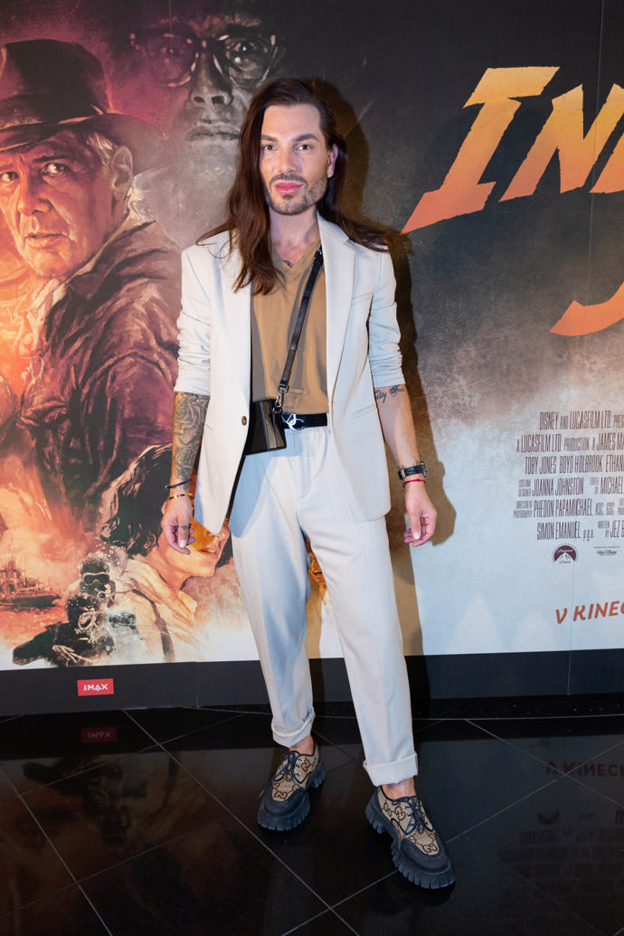 Stylista Sam Dolce nosí široké kalhoty v krémové barvě.