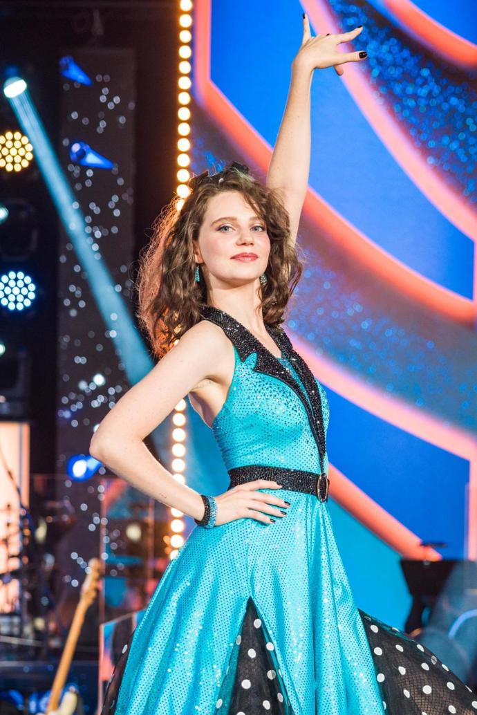 Darija Pavlovičová ve vyžehlených a následně zvlněných vlasech s černou mašlí uprostřed.