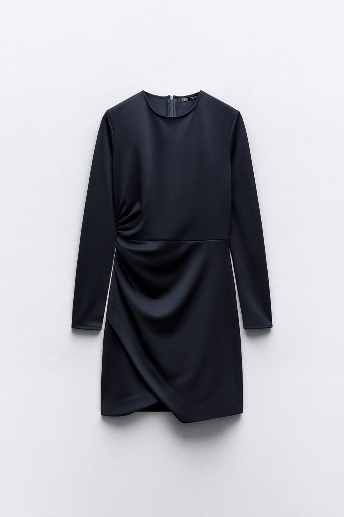 Malé černé se zavinovacím prvkem a řasením. Dlouhé rukávy a střídmý výstřih nahrávají nositelkám vyššího věku. (Zara, 799 Kč)