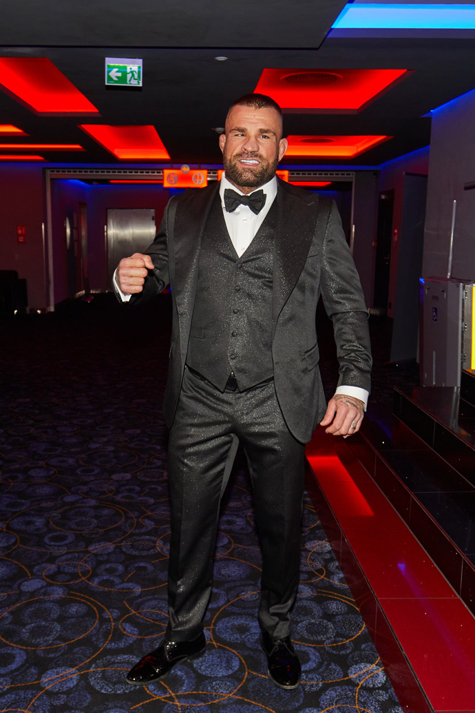 Hlavní hvězda dokumentu, bijec Karlos Vémola, vynesl tmavě šedý oblek ze třpytivého materiálu. Nechybí mu vestička, manžetové knoflíčky ani motýlek.