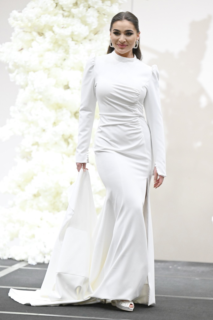 Absence zdobení, o to rafinovanější střih. Dlouhé rukávy s výraznými rameny a nekonečná vlečka se o poprask postarají i bez pozlátka.