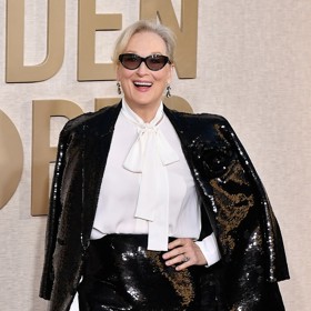 Herečka model doladila svými ikonickými obroučkami brýlí, stříbřitým pouzdrovým psaníčkem a sadou diamantových šperků.