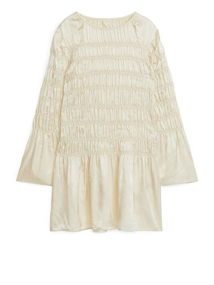 Snížená linie pasu vytvořená řasením, a podpořená stejným prvkem na rukávech. (Arket, 1 590 Kč)