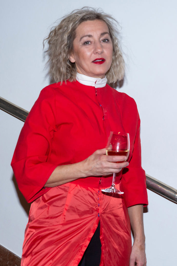 Herečka zvolila netradičně střižený kabátek s propínáním a prodlouženou "sukňovou" partií z odlišného materiálu, která se rozevírala a odhalovala znovu objevený módní prvek současnosti - vrstvení šatů či sukní přes kalhoty.