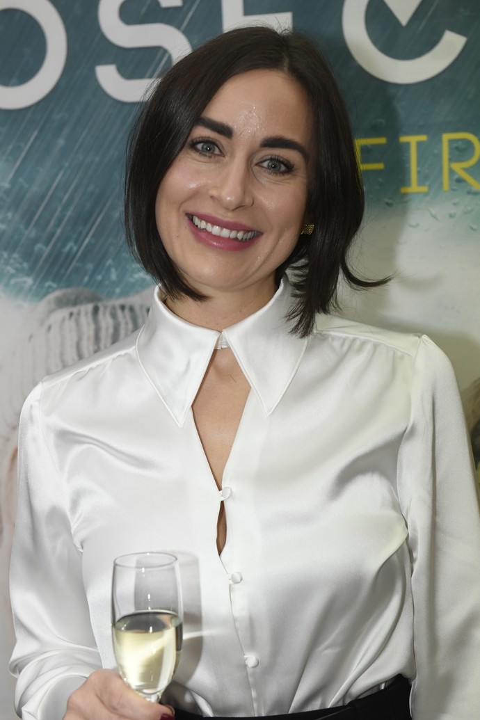 Široký střih nohavic umocněný vysokým pasem a nápadným páskem zkombinovala s kontrastní saténovou blůzou. Tu ozdobil netradiční tvar výstřihu.