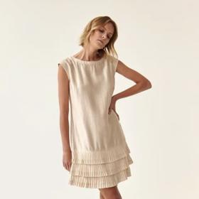 Snížená pasová linie může mít podobu volánů v délce šatů áčkového střihu. (Tatuum)