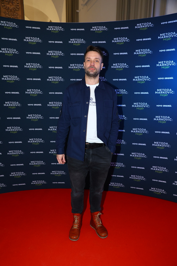 Herec Václav Neužil oblékl bílé basic tričko, přes které přehodil tmavě modrou košili, ke které sladil džínové kalhoty. Boty zvolil Neužil v odvážné variantě červené kůže.