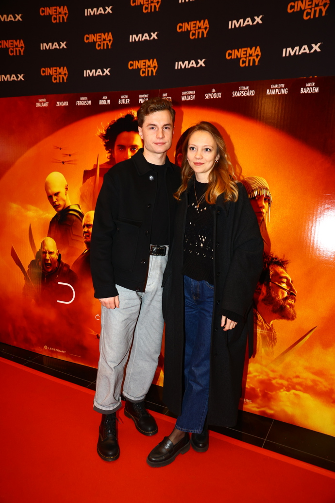 Herec Oskar Hes se trendy stylingu nebojí a světlé džíny nosí s velmi vysokým pasem, přepásané širokým koženým páskem. Také jeho partnerka oblékla k černému zbytku outfitu džínovou klasiku.