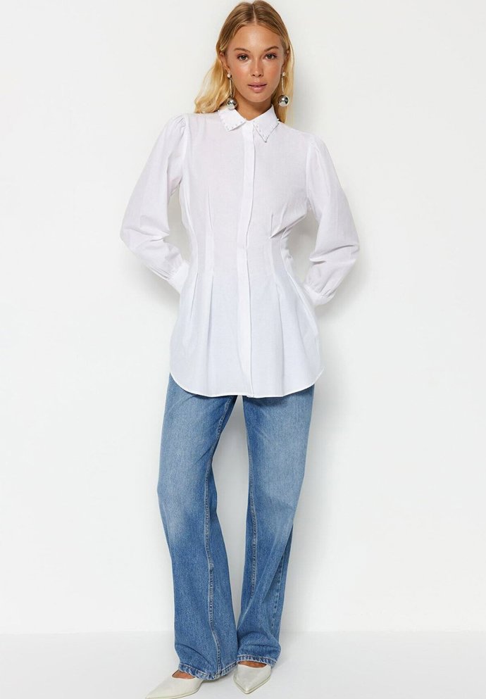 Bílá košile, to je základ, bez kterého se zkrátka neobejdete. Aktuální trend ale velí přidat do šatníku ryze ženskou variantu, které nechybí silueta a tvarovaný pas. (Trendyol, 895 Kč)
