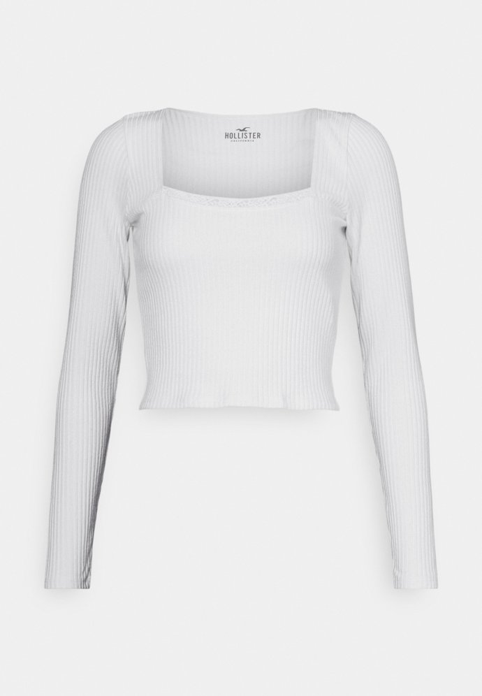 Přiléhavý top ve zkrácené délce zdobí bordura a hranatý výstřih. (Hollister&Co., 539 Kč)
