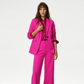 Výrazné odstíny hrají letos prim. Fuchsiově růžový kostým najdete v nabídce značky Marks&Spencer. (Sako, 2 499 Kč, kalhoty, 1 499 Kč)