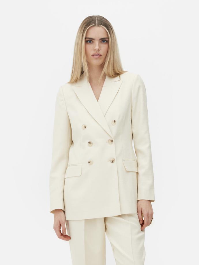 Zpěvačka ale podlehla i dalšímu trendu, světlým kostýmům. Tento v odstínu slonové kosti sestává z dvouřadého saka a elegantních rovných kalhot. (Rita Ora for Primark, sako, 885 Kč, kalhoty 520 Kč)