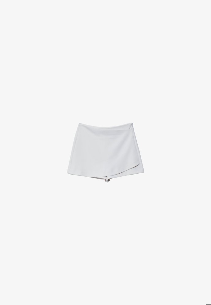 Jednoduchá "skort" v něžně bílém provedení. (Stradivarius, 549 Kč)