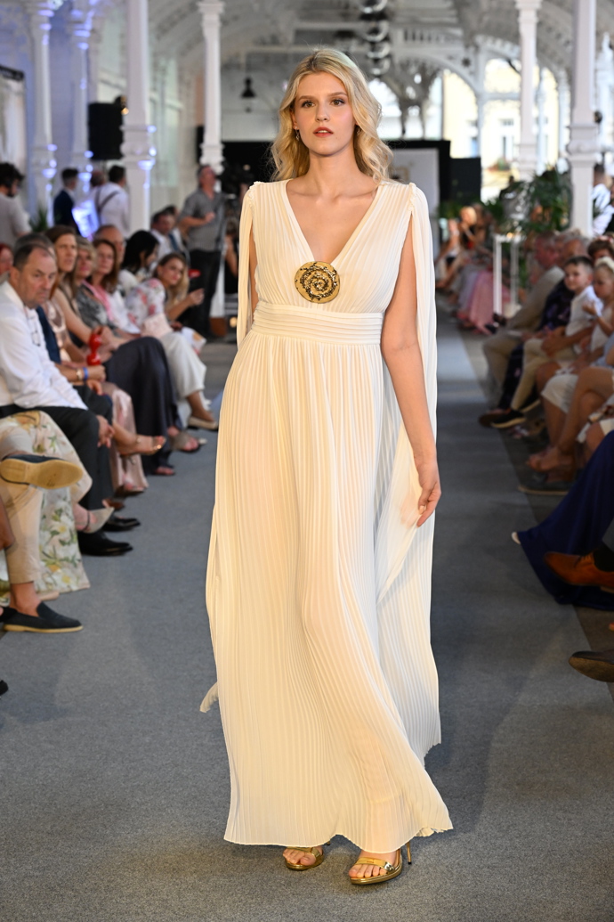 Krémové šaty s dlouhou vlečkou a hlubokým výstřihem ve stylu antické bohyně. 