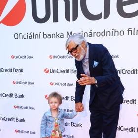 Jiří Bartoška ukazuje Andulce zástup fotografů. 