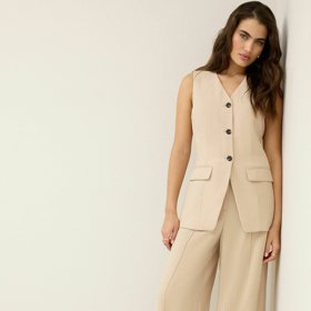 Elegantní švih tomuto trendu rozhodně neschází. Vybírat navíc můžete z mnoha líbivých variant, třeba této kombinace prodloužené vesty ve stylu saka a extra širokých nohavic kalhot formálního typu. (Next, vesta 1 750 Kč, kalhoty 1 640 Kč)