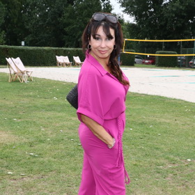 Herečka Nela Boudová ve slušivém a pohodlném overalu vyvedeném v zářivé fuchsiové barvě.