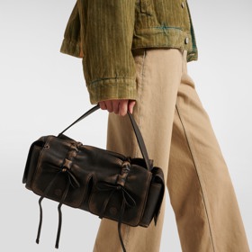 Model od značky Acne Studios zdobí stahování a mašličky.