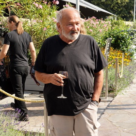 Rudolf Hrušínský mladší si vychutnával červené víno v tmavém tričku a béžových cargo kalhotách. 