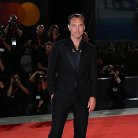 Krasavec, který také takřka nestárne, doladil o triko s hlubokým výstřihem a hedvábnou šálku klasicky střižený smoking Brioni.