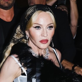 Model doplňovalo péřové boa a také nepřehlédnutelný krajkový šátek, kterým si diva překryla platinově blond vlasy sahající až do pasu.