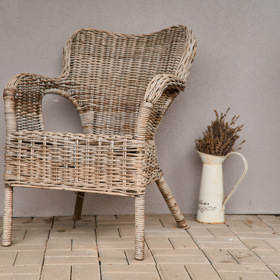 Křeslo na terase při vchodu na zahradu láká k posezení.