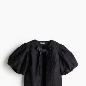 Tuto blůzu s nadýchanými rukávy zdobí ještě vázačka u krku. (H&M,  479 Kč)