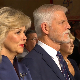 Vizážistka první dámy doladila tmavomodrý model elegantním kouřovým líčením a zářivě rudou, matnou rtěnkou.