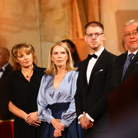 Spisovatelka Karin Lednická oblékla pastelově modrou saténovou halenku doplněnou o tmavě modrou skládanou sukni áčkového střihu.