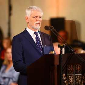 Prezident České republiky Petr Pavel  oblékl tmavě modrý oblek doplněný o tmavě modrou kravatu s červeno-bílými motivy.