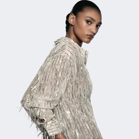 Jednoduchá košile ozvláštněná flitry a třásněmi nemusí zahálet ve skříni. Vynosíte ji bez problémů i přes den. (Zara, 849 Kč)