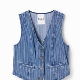 Do výbavy vhodné pro současné období patří i jednoduchá vesta oblekového typu ušitá z modré džínoviny. Desigual, 1 049 Kč