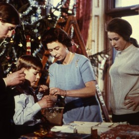 Každý z hostů také přinese svoji kouličku na vánoční stromek, pod který se nadělují dárky už na Štědrý den večer. Na archivní fotografii z roku 1969 zdobí stromek královna Alžběta spolu se syny Charlesem a Andrewem a dcerou Anne.