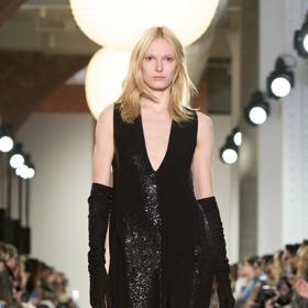 Trend, který můžeme brzy čekat i v ulicích a dobře jej známe už z přelomu tisíciletí. Šaty nošené přes kalhoty v podání Michaela Korse.