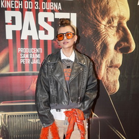 Raperka Sharlota oblékla šedivý kožený křivák doplněný o oranžové brýle, kabelku a šátek. Vše perfektně sladěno. 