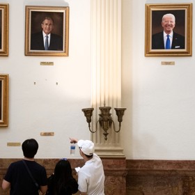 Lidé si prohlížejí prázdné místo po portrétu Donalda Trumpa.