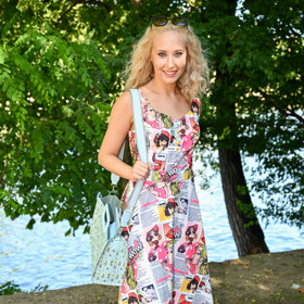 Denisa Grossová oblékla šaty áčkového střihu s barevným potiskem a doplnila je modrou kabelkou a modrými teniskami. 