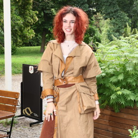 Anna Dvořáková vynesla světle hnědý plášť se zajímavými koženými detaily a hnědé široké kalhoty.