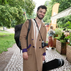 Šimon Bilina přehodil přes svůj bílý outfit béžový kabátek s fialovými detaily.