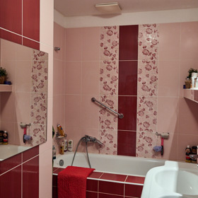 Koupelna je vyladěna do teplých červených odstínů. 