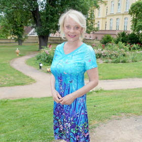 Veronika Jeníková oblékla tyrkysové šaty s barevnými aplikacemi. Doplnila je bílými střevíčky s uzavřenou špičkou. 