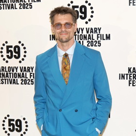 Nápadně barevný oblek stylově doplnil neméně zajímavou kravatou a brýlemi.