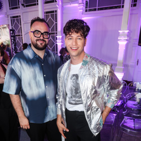 Milan Peroutka přehlídku moderoval a v rámci dress codu oblékl metalický stříbrný bomber, bílé tričko s potiskem a černé společenské kalhoty. Doprovod mu dělal partner Dominik. 