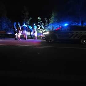Policisté se zadrženým mužem během zásahu.