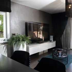 Obývací část má velké prosklené dveře, které vedou právě k jedné ze sedacích částí na zahradě. 