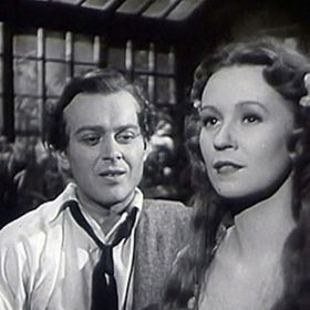 Snímek z filmu Okouzlená: Začínající herečka se zamiluje do doktora Pavla Chvojky, který ji opustí i s dítětem. Ona se ale nevzdá a dál bojuje za svůj sen. Na fotce s Natašou Gollovou je Karel Höger.