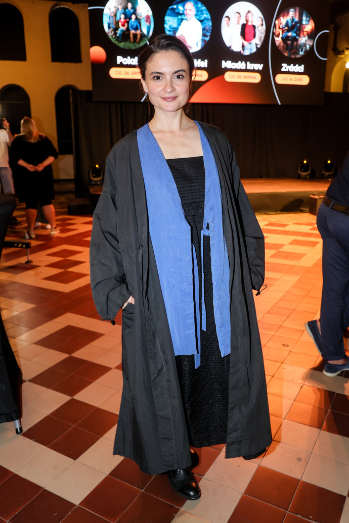 Herečka Eva Podzimková oblékla černý kabát a modrý svetřík. 