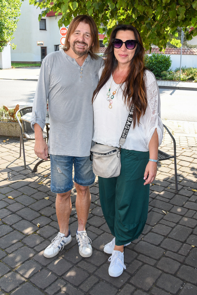 Bohouš Josef s manželkou Alenou, která oblékla bílou halenku a tmavě zelené harémové kalhoty. K tomu nazula bílé tenisky. 