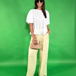 Oblíbený outfit stylistky Nikoly Markové - bílá halenka, pohodlné a lehké kalhoty s proužkem a k tomu hnědé doplňky. 